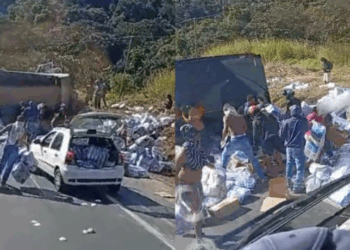 Caminhão carregado com fraldas tomba na BR-381, em São Gonçalo do Rio Abaixo (MG), e carga é saqueada por populares. PRF interdita parcialmente a via.