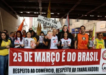 Manifestantes na Rua 25 de Março, em São Paulo, reagem a tarifas de Trump e acusam o presidente dos EUA de atacar a soberania nacional. Ato organizado por sindicatos denuncia interferência e riscos à economia brasileira.