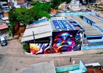 ONG na Cidade de Deus instala faixa pedindo cuidado em operações com helicópteros. A ONG Nóiz atende 250 crianças e se tornou símbolo de resistência e esperança em meio à violência.