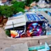 ONG na Cidade de Deus instala faixa pedindo cuidado em operações com helicópteros. A ONG Nóiz atende 250 crianças e se tornou símbolo de resistência e esperança em meio à violência.