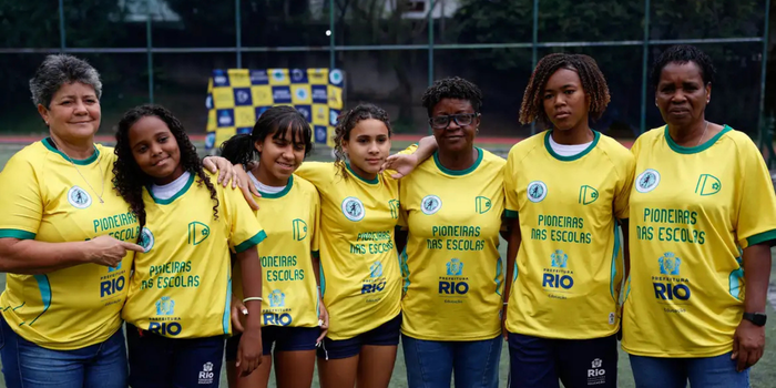 Ex-jogadoras da Seleção Brasileira visitam escola municipal no Rio de Janeiro, compartilham experiências contra o preconceito e inspiram alunas por meio do futebol.
